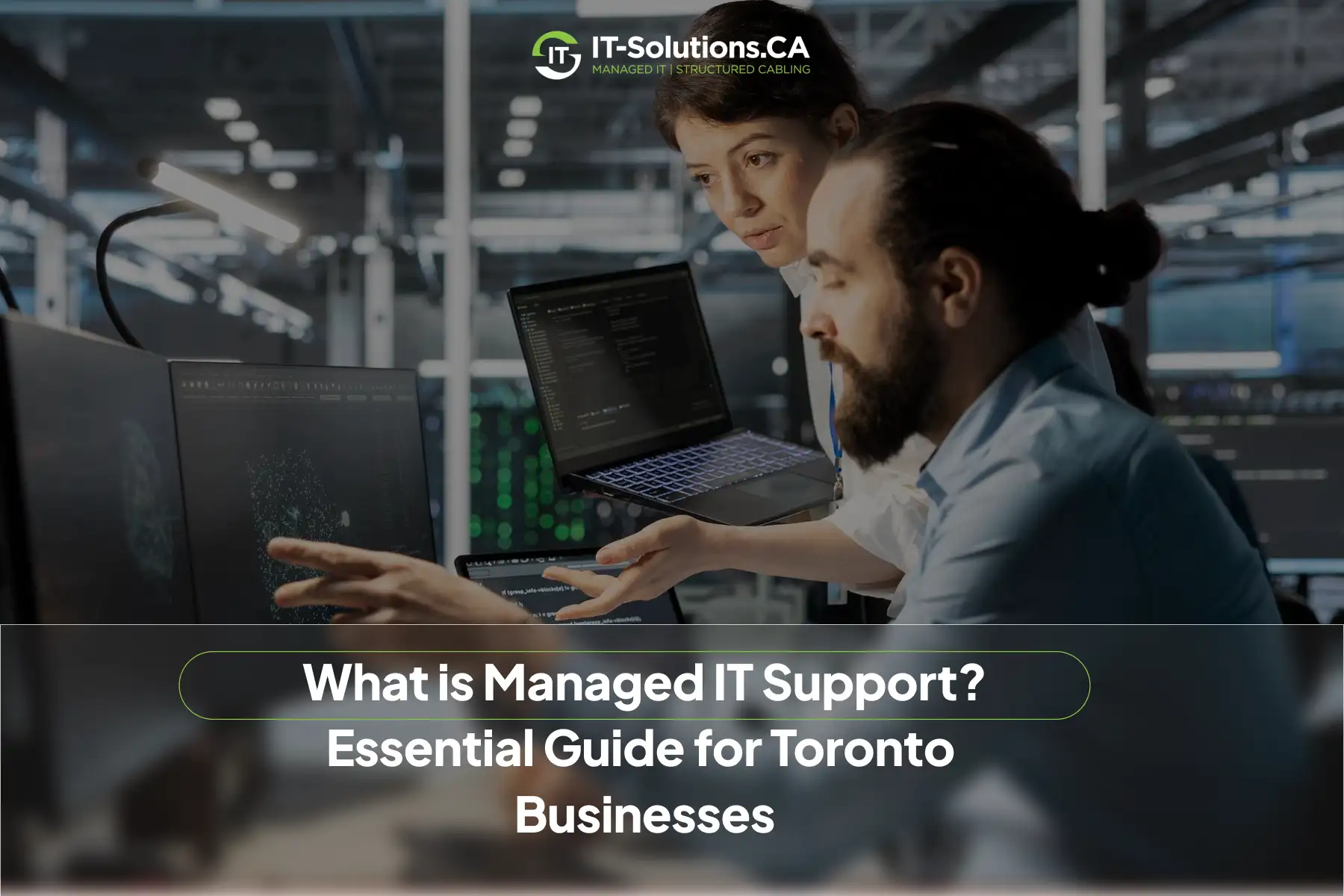 Two IT technicians reviewing code and security data on computer monitors in a dark server room.