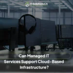 Darkened view of a modern workstation with multiple monitors and a headset, highlighting managed IT infrastructure support.